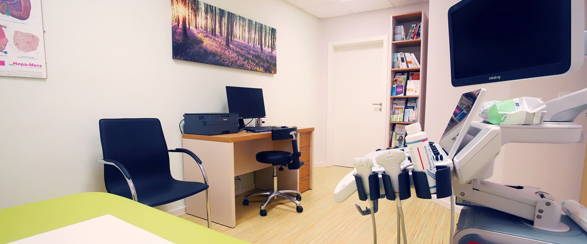 Referenz Praxis für Allgemeinmedizin Altenburger Blick von einer Liege neben einem Ultrashallgerät in einem Sprechzimmer in Richtung Schreibtisch